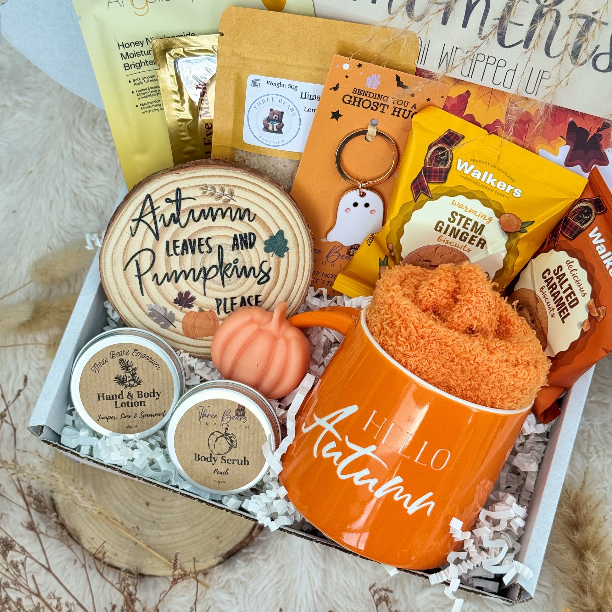Autumn-themed gift box with items like a mug, keychain, and body scrub.